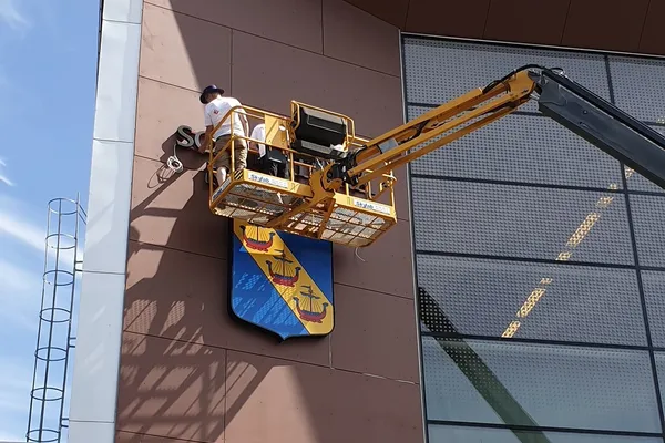 Pågående montering av stor fasadskylt åt Sollentuna Kommun